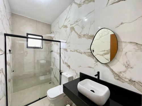 a bathroom with a sink and a mirror at Casa em Condomínio a 290 metros da Praia no Condomínio Costa do sol in Bertioga