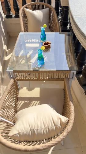 a wicker chair with a table with a blue bottle on it at Crowne Pyramids View inn in Cairo