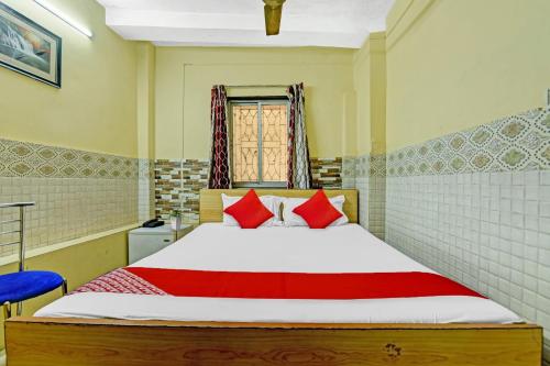 a bedroom with a large bed with red pillows at Hotel O jaapon in Calcutta Bara Bazar