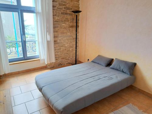 un grand lit dans une chambre avec une fenêtre dans l'établissement First floor studio near the beach, au Pouldu