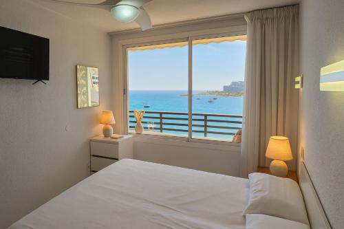 a bedroom with a large window with a view of the ocean at Doñana Beachfront y acceso directo a la playa de Patalavaca in Patalavaca