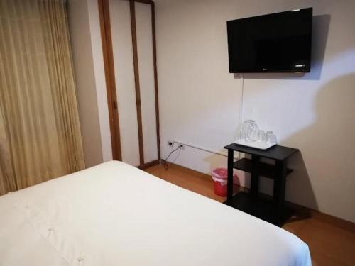 a bedroom with a bed and a flat screen tv at Hotel Sol Internacional in Sogamoso