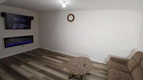 a living room with a couch and a table and a clock at Modern 2-Bedroom and 2-Bed Apartment with Private Access Door Minutes from I-81 in Hedgesville