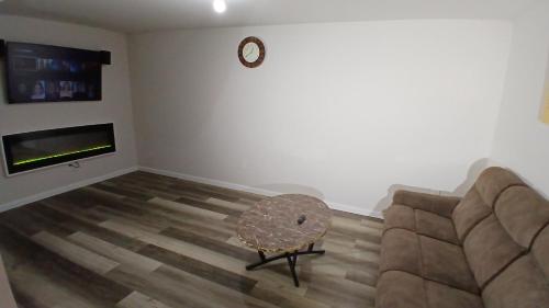 a living room with a couch and a clock on the wall at Modern 2-Bedroom and 2-Bed Apartment with Private Access Door Minutes from I-81 in Hedgesville