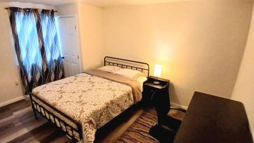 a small bedroom with a bed and a window at Modern 2-Bedroom and 2-Bed Apartment with Private Access Door Minutes from I-81 in Hedgesville