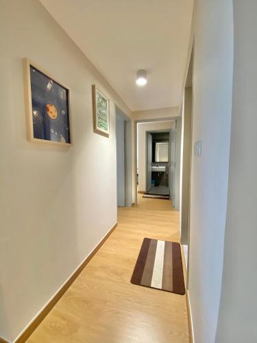 a hallway with a small rug on a wooden floor at Zawirah guesthouse mayabay splashmania in Banting