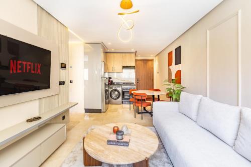 un salon avec un canapé blanc et une table dans l'établissement Prestige Apartment in City Center, à Marrakech