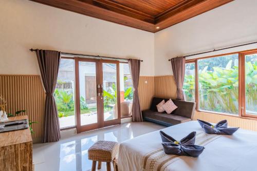 ein Schlafzimmer mit einem Bett und einem großen Fenster in der Unterkunft Pondok loji luxury villa in Ubud