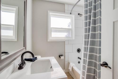 a white bathroom with a sink and a window at Just Beachy in Lincoln City