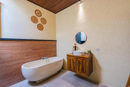 ein Badezimmer mit Badewanne und Waschbecken in der Unterkunft Pondok loji luxury villa in Ubud