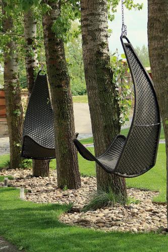 a hammock hanging from two trees in a park at Autóscsárda és Panzió in Makó