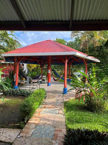 a pavilion with a red roof with a playground at Chinitas Eco Lodge in Tortuguero