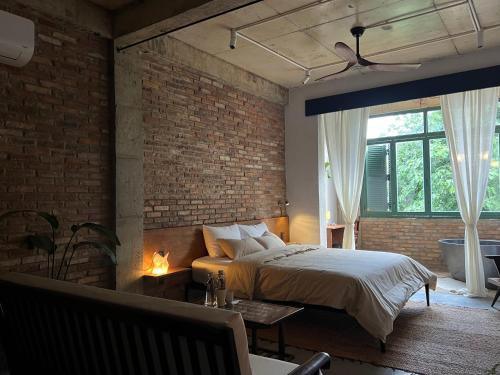 a bedroom with a bed and a brick wall at PREEZE boutique stay in Vung Tau
