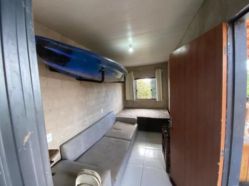a small room with a couch and a window at Los Arboles - Quarto com Banheiro in Alexânia