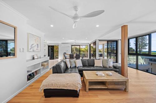 a living room with a couch and a table at Beachfront with pool ocean views and pet friendly in Buddina