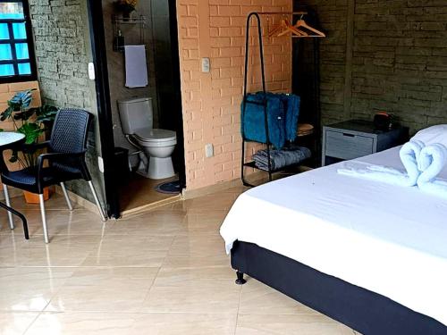 a bedroom with a bed and a bathroom with a toilet at Cabañas Quinta Gabian - Glamping in Villavicencio
