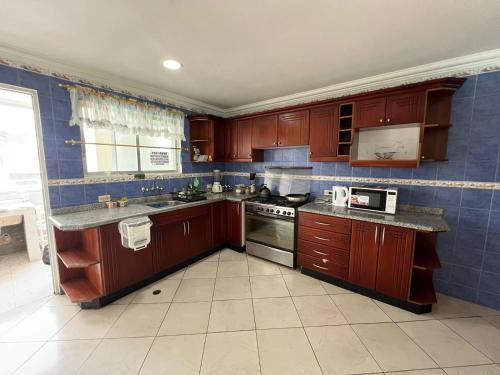 a kitchen with wooden cabinets and a stove top oven at Departamento Casco Centrico con Garage in Loja