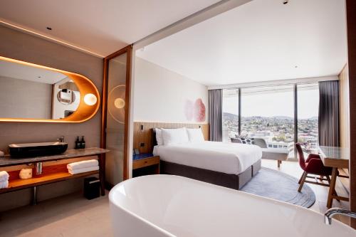 a hotel room with a bed and a bath tub at Crowne Plaza Hobart by IHG in Hobart