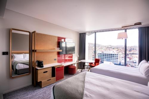 a hotel room with two beds and a mirror at Crowne Plaza Hobart by IHG in Hobart