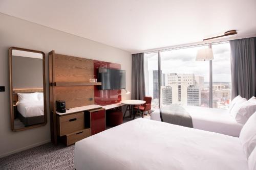 a hotel room with two beds and a mirror at Crowne Plaza Hobart by IHG in Hobart