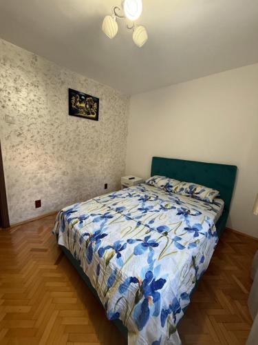 a bedroom with a bed with a blue and white comforter at Studio Turda in Turda