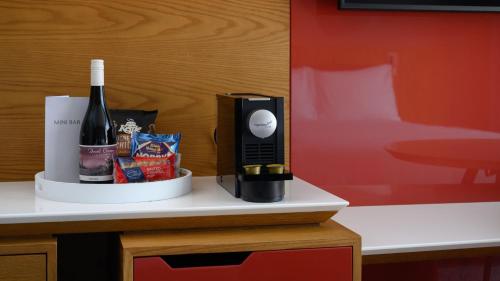 a bottle of wine and a phone on a table at Crowne Plaza Hobart by IHG in Hobart
