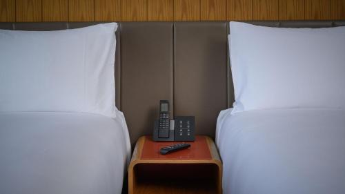 two twin beds with a phone on a table between them at Crowne Plaza Hobart by IHG in Hobart