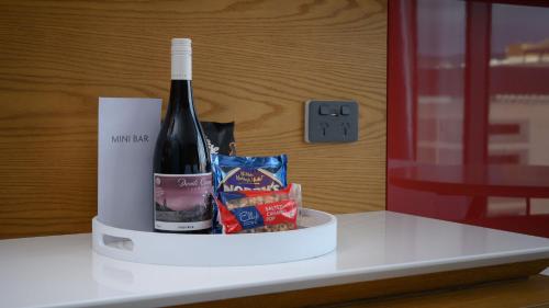 a bottle of wine and some chips on a counter at Crowne Plaza Hobart by IHG in Hobart