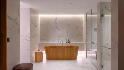 a bathroom with a wooden tub and a shower at Crowne Plaza Hobart by IHG in Hobart