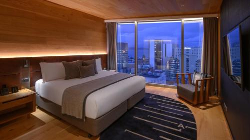 a bedroom with a large bed and a large window at Crowne Plaza Hobart by IHG in Hobart