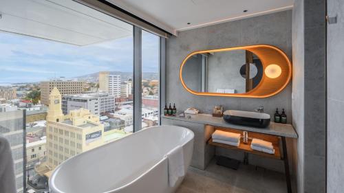 a bathroom with a tub and a large window at Crowne Plaza Hobart by IHG in Hobart