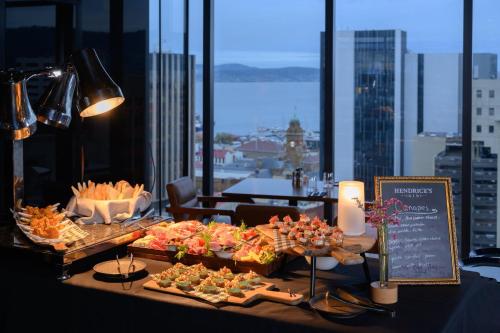 a buffet of food on a table with a view of a city at Crowne Plaza Hobart by IHG in Hobart