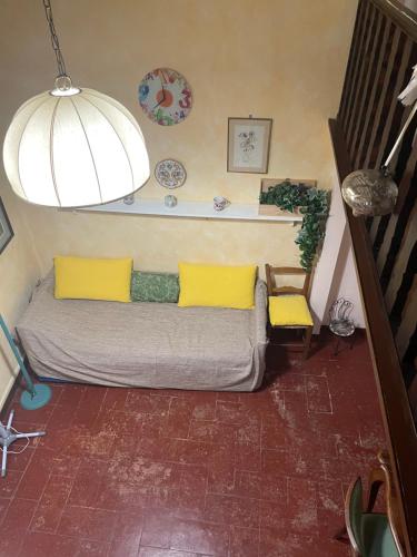 a couch with yellow pillows in a living room at Appartamento nel cuore di Todi in Todi