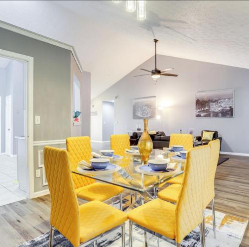 ein Esszimmer mit einem Glastisch und gelben Stühlen in der Unterkunft Stylish Retreat in Lawrenceville in Lawrenceville