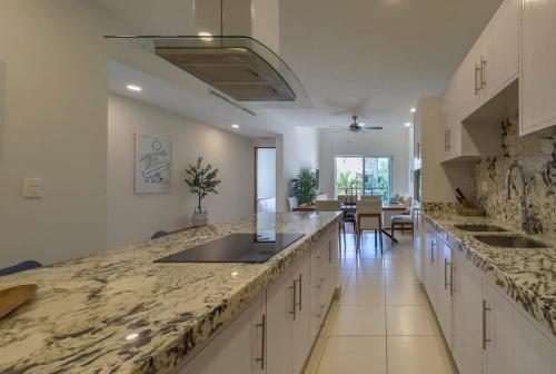 a large kitchen with marble counter tops and a dining room at 2BR Apt with Lagoon View in Puerto Aventuras in Puerto Aventuras