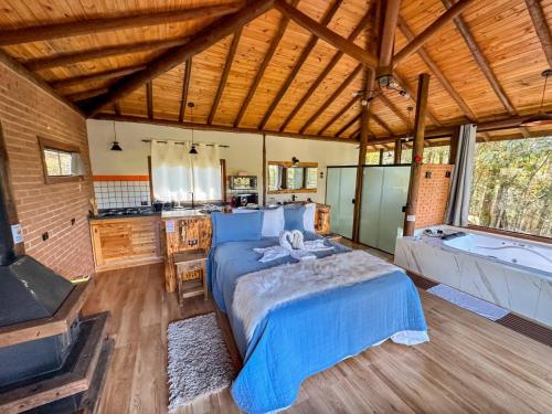 a large bedroom with a bed and a bath tub at Chalé Valle dos sonhos in Gonçalves