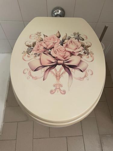 a toilet with a bouquet of pink roses on it at Appartamento nel cuore di Todi in Todi