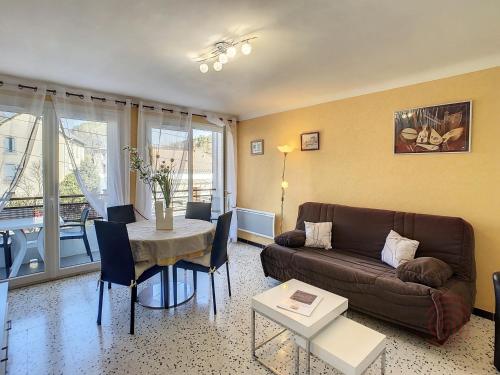 un salon avec un canapé et une table dans l'établissement Appartement F2 moderne à Lamalou-les-Bains, proche thermes, balcon, Wi-Fi, animaux acceptés - FR-1-451-204, à Lamalou-les-Bains