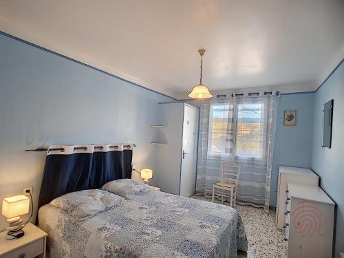 une chambre avec un lit et un mur bleu dans l'établissement Appartement F2 moderne à Lamalou-les-Bains, proche thermes, balcon, Wi-Fi, animaux acceptés - FR-1-451-204, à Lamalou-les-Bains