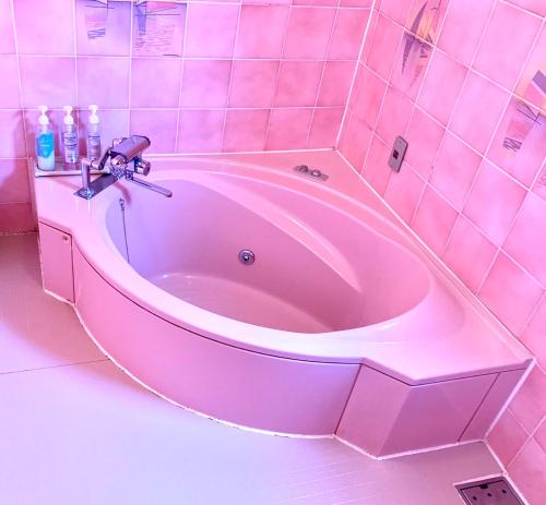 a pink bath tub in a pink tiled bathroom at JOY GARDEN in Taku
