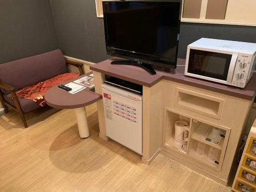 a living room with a tv and a microwave at JOY GARDEN in Taku