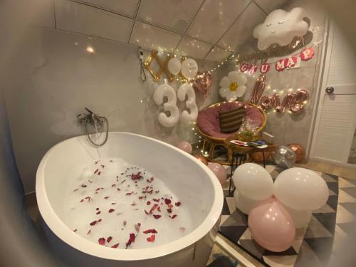 a bathroom with a tub and balloons and a cake at Blue Windy Đà Lạt Homestay in Da Lat