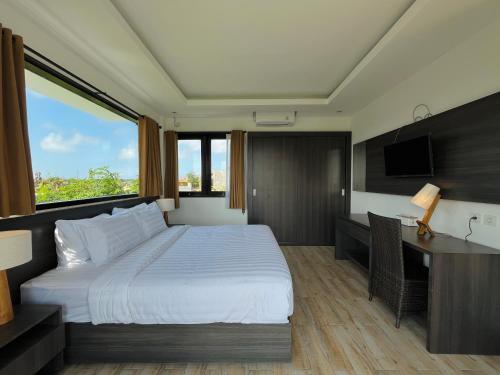 une chambre avec un lit, un bureau et une télévision dans l'établissement Telaga Villa Ungasan, à Uluwatu