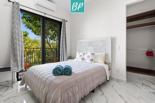 a bedroom with a bed with two blue towels on it at Stanza Bucerias Condos - Pool Parking & Near Beach in Bucerías