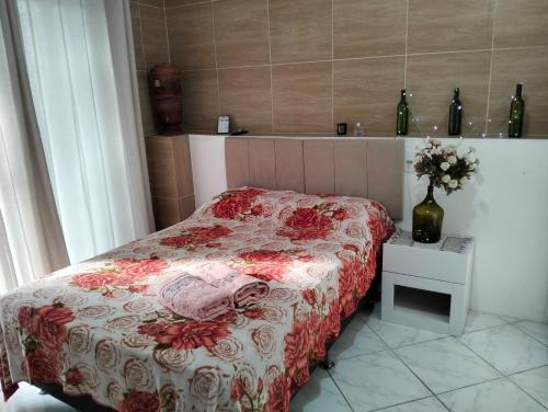 a bedroom with a bed with a red and white comforter at Suíte com Entrada Independente in Florianópolis