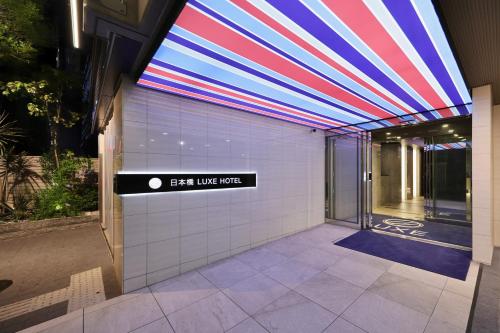 an entrance to a building with a sign that reads exit useptic at Nipponbashi Luxe Hotel in Osaka