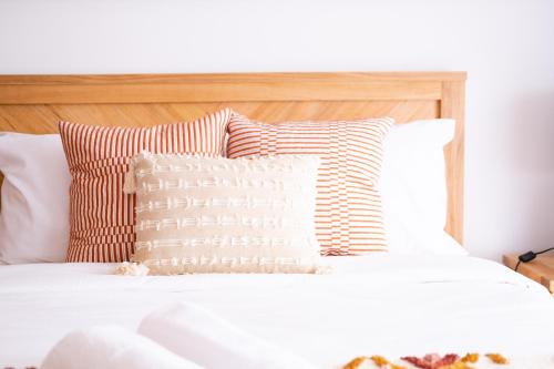 a bed with white sheets and pillows on it at Bateau Bay in Bateau Bay