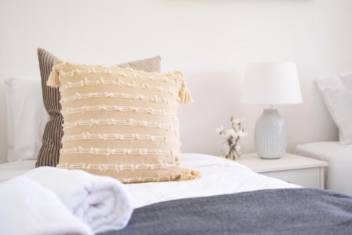a bed with a pillow on top of it at Bateau Bay in Bateau Bay