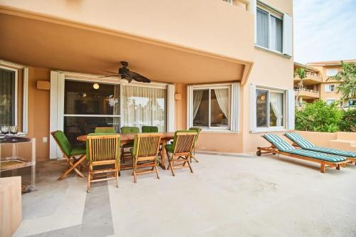 a patio with a wooden table and chairs at BeachFront Appt w/Amazing Pool in Puerto Aventuras in Puerto Aventuras