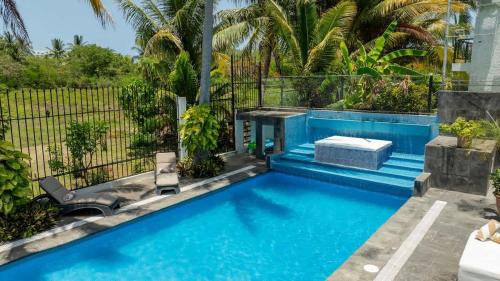 a swimming pool in a backyard with two chairs and a swimming pool at Casa Coco - 4BR | Private Pool | Hotel Zone in Cancún